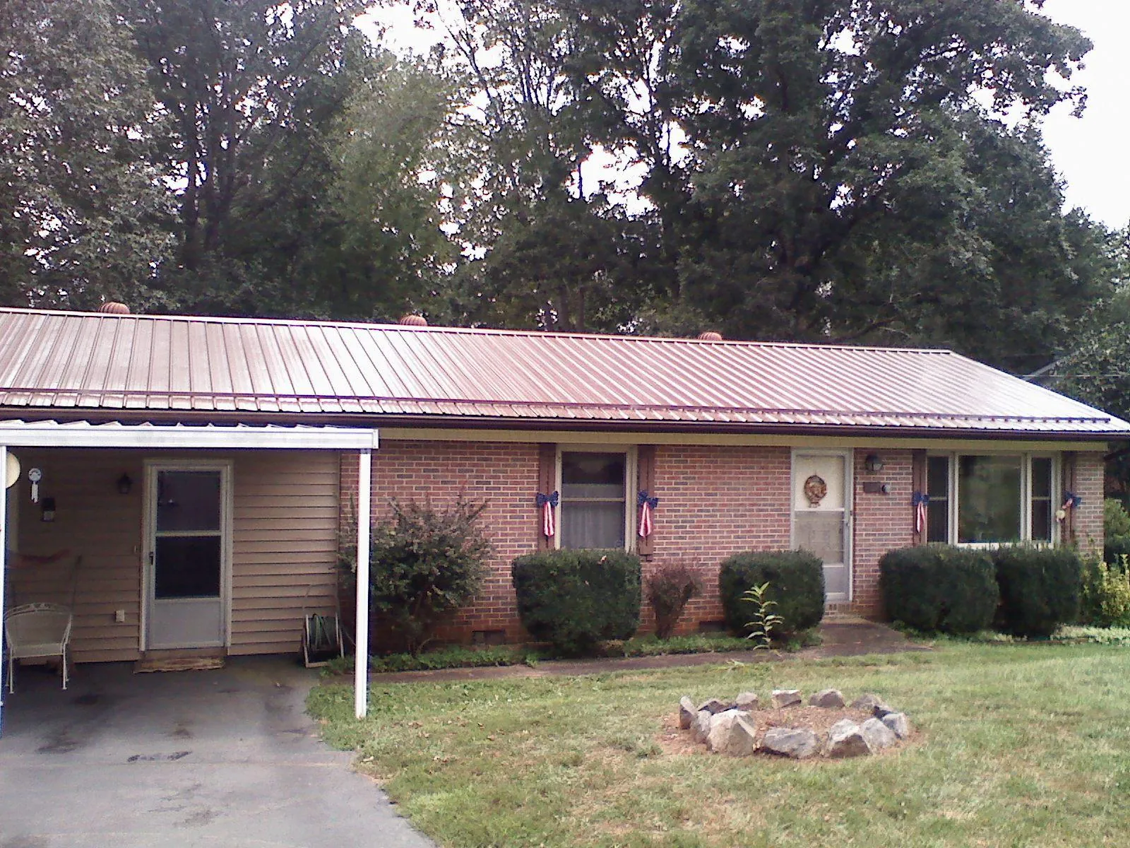Bronze metal roof and carport on a brick ranch home — Roof Repair work by our crew in Brooksville